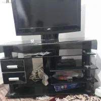 تلویزیون ۴۲ اینج با میز شیشه تر‌ک همراه وسایلش