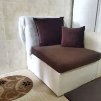 مبل یک نفره، دو کوسن و یک شال مبل پشمی