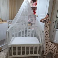 گهواره و تخت چوبی کنار مادر