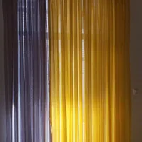 تعدادی پرده حریر طوسی و زرد رنگ آماده نصب