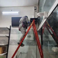 کار آموز و بر دست نوجوان برقکاری دوربین مدار بسته