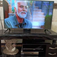 تلویزیون ال ای دی به همراه میزشیشه ای ترک