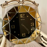 ساعت دیواری  آینه ای و تعدادی گلدان و مجسمه دکوری