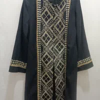 تعداد زیادی مانتو زنانه بلند رنگ مشکی و طرح دار