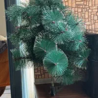 درخت کریسمس کوچک و تعدادی زنگوله آویز درخت کریسمس