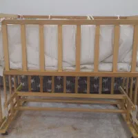 گهواره کنار تخت مادر و تعدادی سیسمونی نوزاد