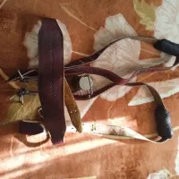 کمربند هیکلی چرم بوفالو و یک کلاه خود و پر طاووس