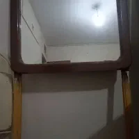 آینه دیواری دور چوب ایستاده