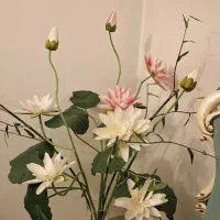 گل مصنوعی نیلوفر آبی و گلدان شیشه ای کنار سالنی