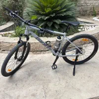 دوچرخه جاینت کوهستان و کلاه و عینک دوچرخه سواری