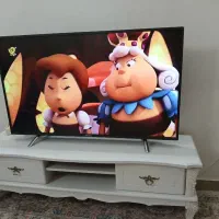 یک عدد تلویزیون همراه میز .