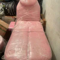 تخت تتو و ماساژ و صندلی چرخدار کنارش